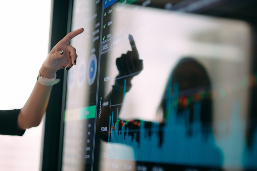 Marketing analyst pointing at a screen with performance graphs
